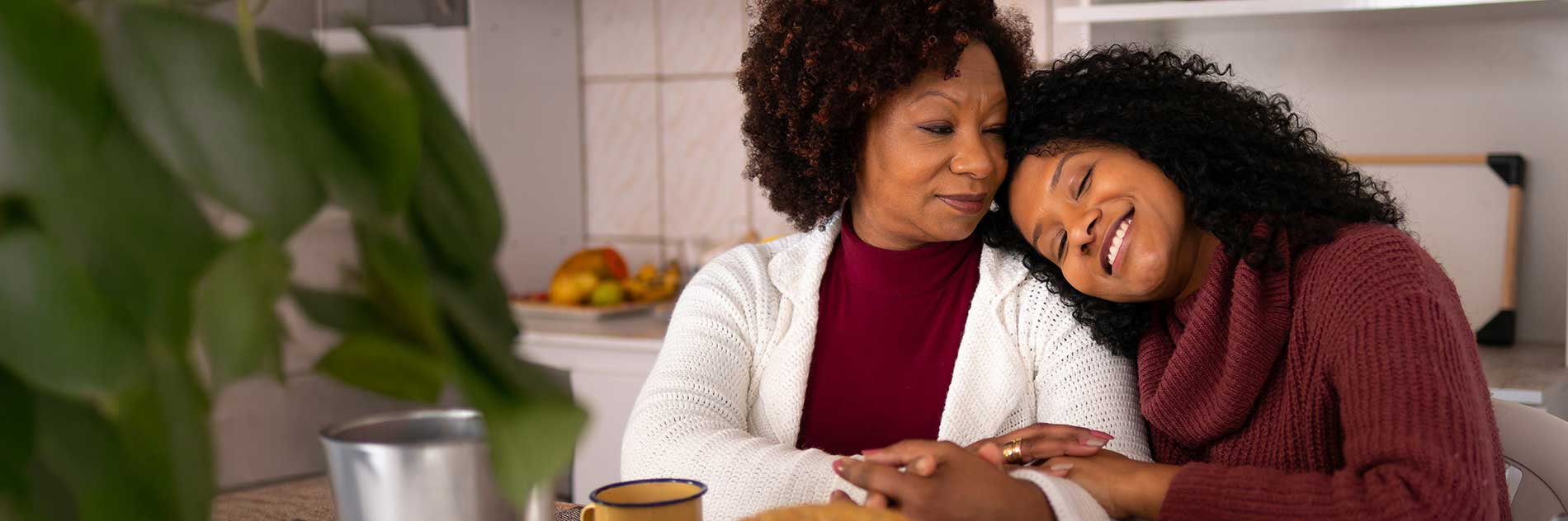 Two women sharing a warm, affectionate moment together at home.
